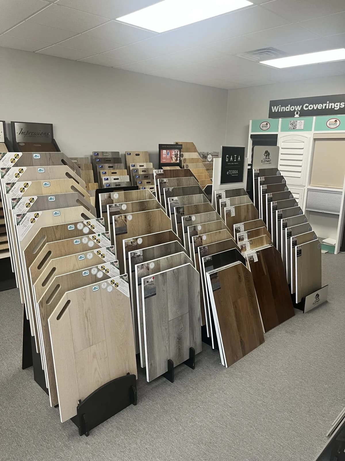 Vinyl plank sample racks with the window coverings section behind, At Home Flooring showroom, Wylie TX